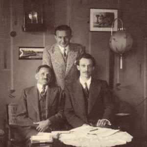 April 1934, im Wohnzimmer von Altbürgermeister Unterguggenberger, mit ihm abgebildet sind Prof. Perroux und G. de Vregille, Mitarbeiter der Zeitschrift Banque in Frankreich